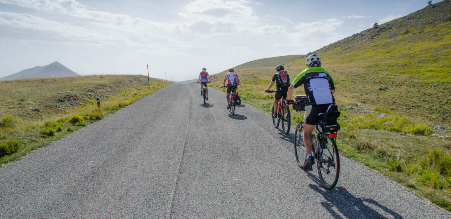 Viaggio di cicloturismo in Abruzzo con ciclisti intenti ad attraversare il Gran Sasso